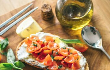 Tomatenbrot mit Olivenöl auf einem Brett.