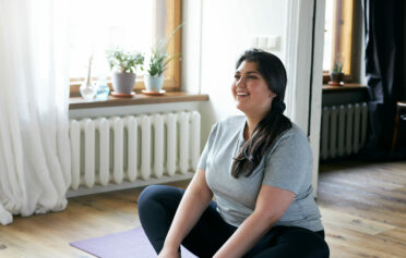 Glückliche junge Frau auf einer Yogamatte