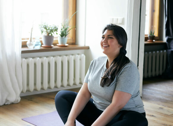 Glückliche junge Frau auf einer Yogamatte