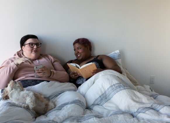 Zwei übergewichtige Personen unterhalten sich im Bett