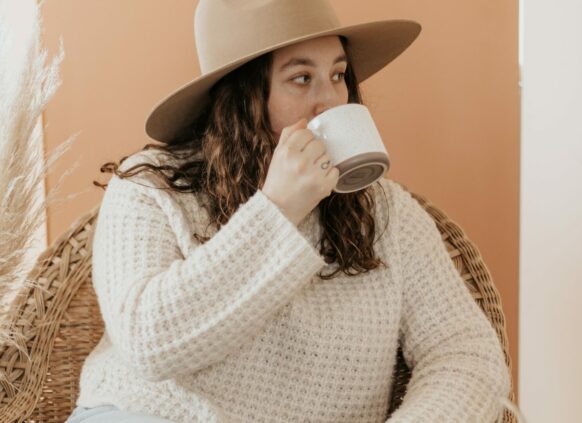Frau mit Hut trinkt Tee