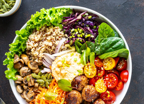 Eine Bowl mit Reis, Huhn, Salat, Tomaten, Falafel, Avocado