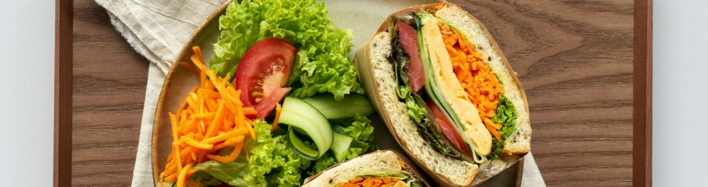 Eine Teller mit gesunden Gemüsesandwiches und Salatbeilage.