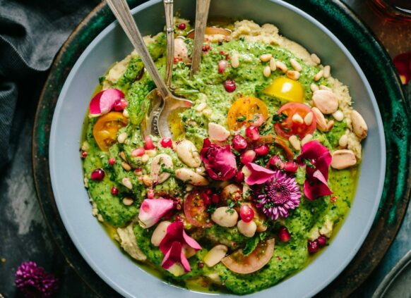 Eine gesunde Bowl mit grünem Gemüse und Nüssen.