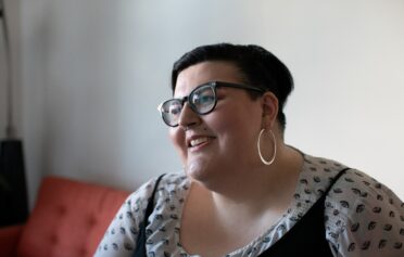 Overweight woman on a couch smiling
