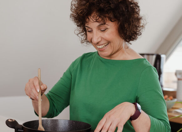 Woman happily cooking a healthy meal