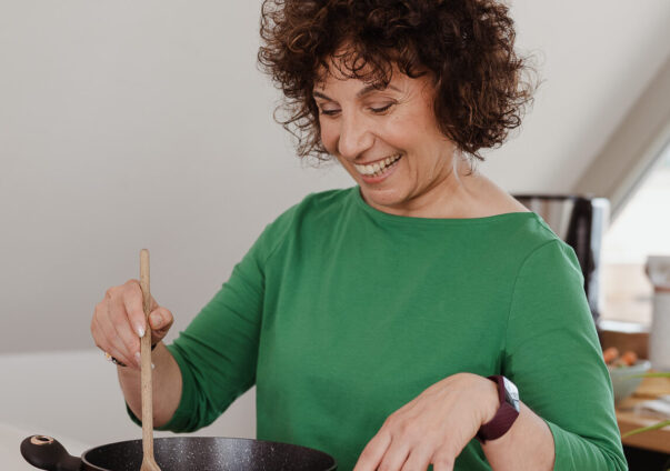 Woman happily cooking a healthy meal