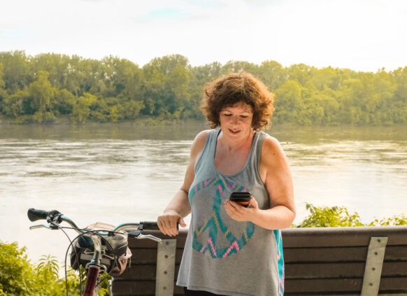 Women taking a break from a bike ride to look at her phone