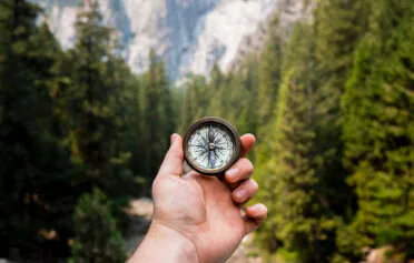 Hand holding a compass in nature